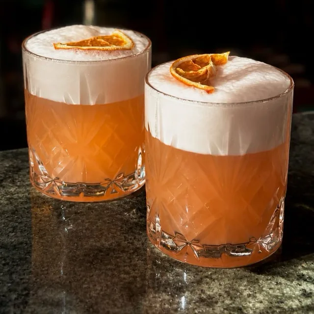 Two citrus-garnished cocktails at Dolores
